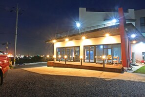 A modern building with large windows and a covered outdoor area. - Sea and Star Pension (Jeju City)