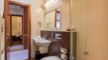 A modern bathroom with a shower, sink, and toilet.