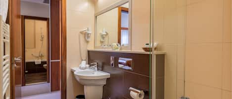 A modern bathroom with a shower, sink, and toilet.
