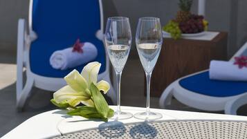 A hot tub with two glasses of champagne and a flower on a table.