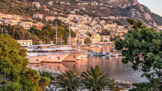 A coastal town with a marina, boats, and buildings. - Hotel Plaza Omis (Omis)