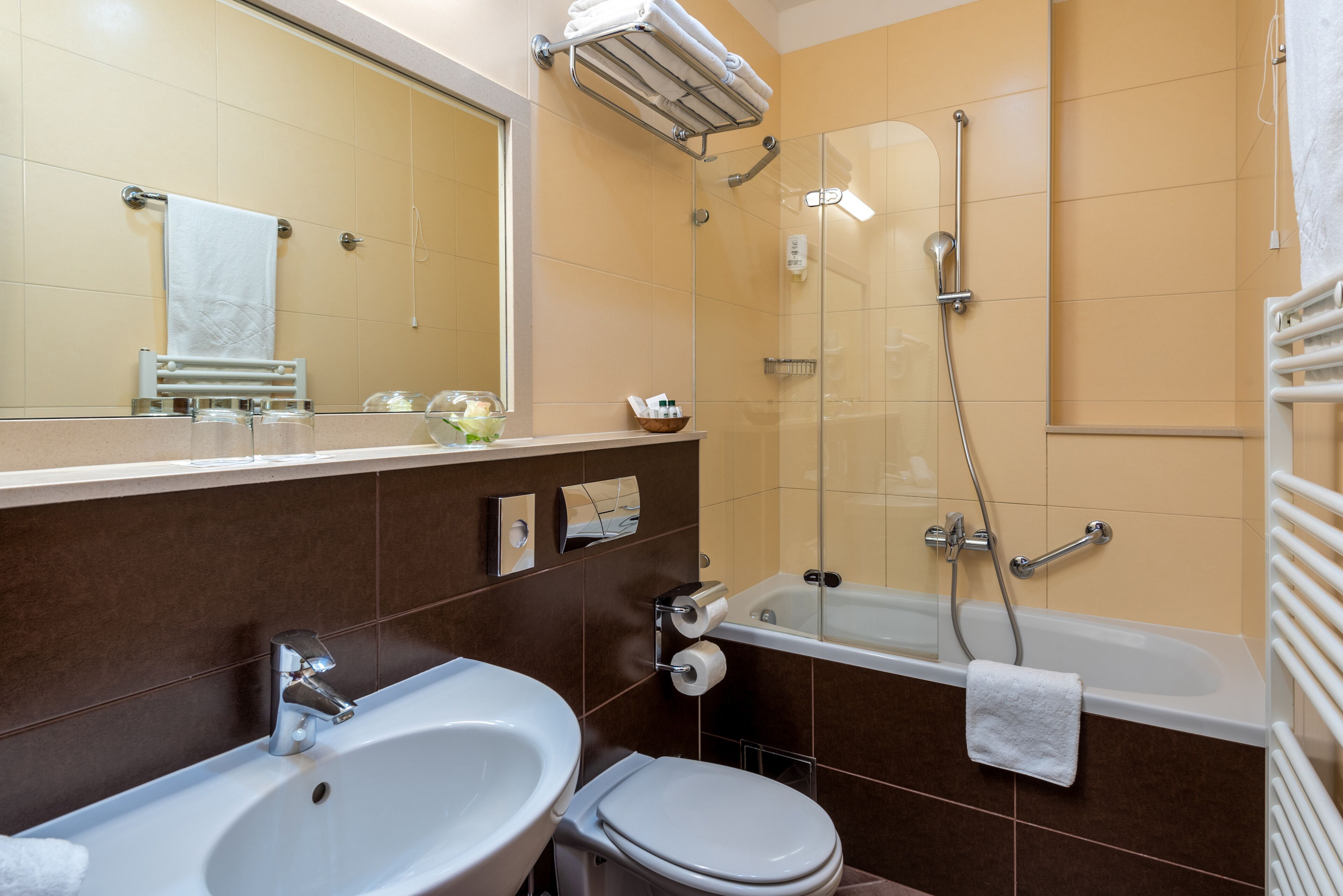 Un baño con lavamanos, inodoro, bañera y cabina de ducha de vidrio.