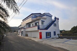 A modern building with a white facade, blue accents, and a red door marked with a 'P'.