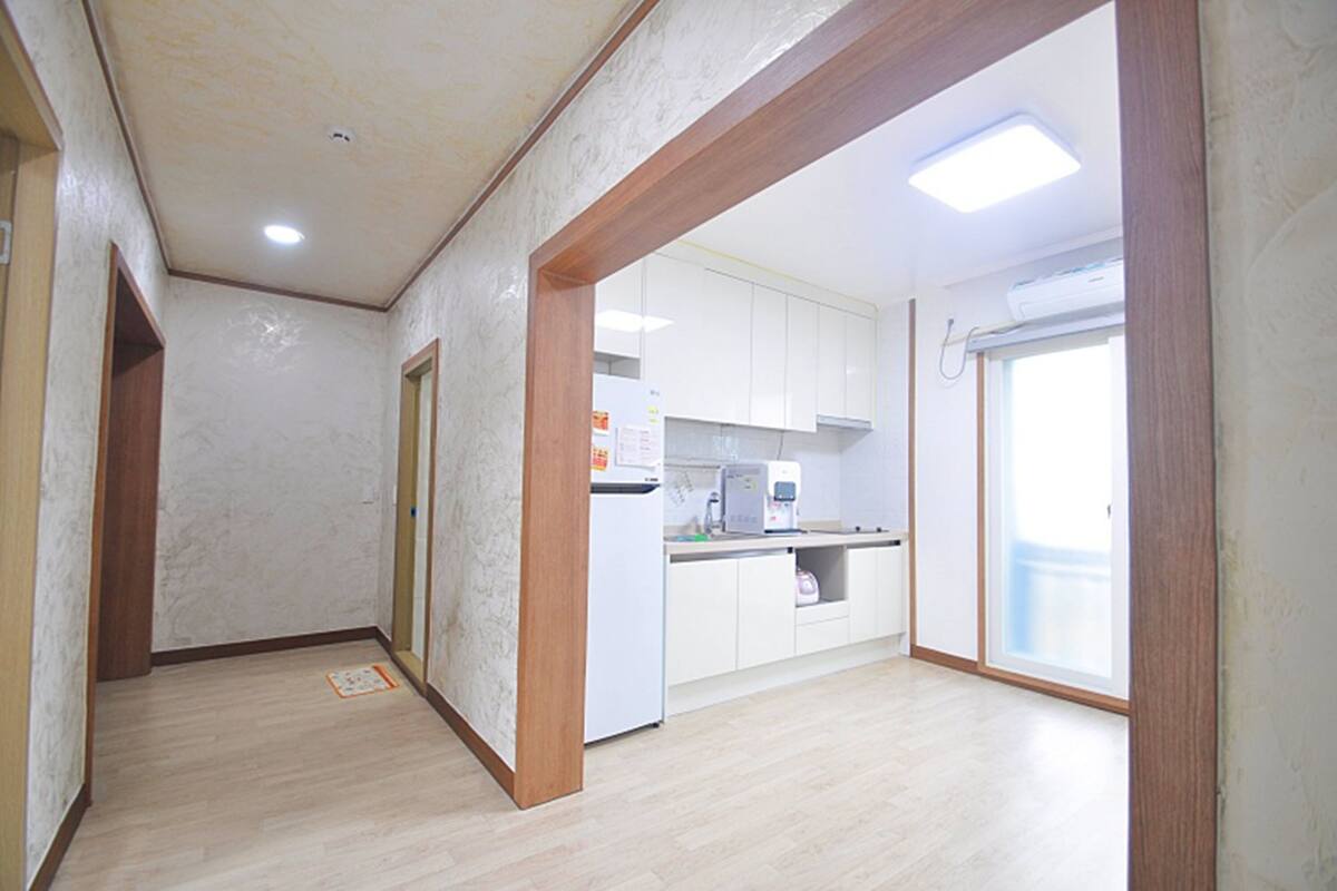 A spacious kitchen with white cabinets, a countertop, and a window.