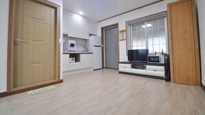 A modern apartment with a kitchen, a dining area, and a living room. - Osio Pension (Jeju City)