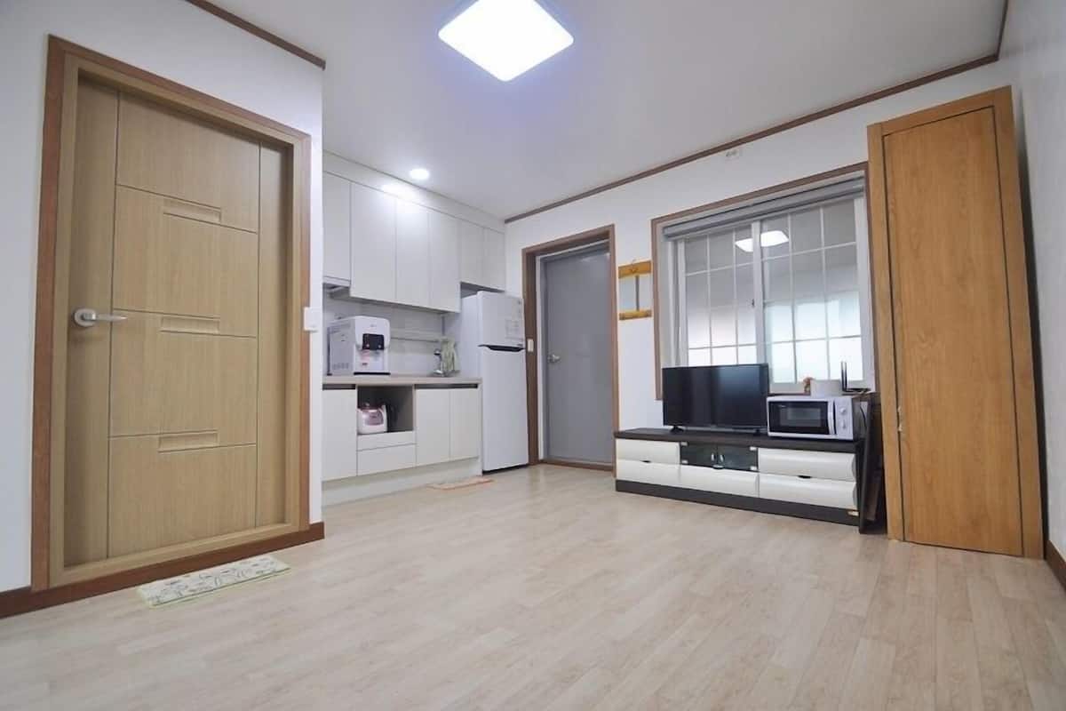 A modern apartment with a kitchen, a dining area, and a living room.