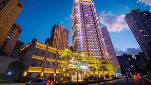 A high-rise hotel with multiple floors, illuminated windows, and a prominent entrance with a sign. - Argyle Resort Dali Yueyun (Dali)
