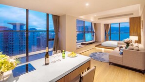 A modern hotel room with a large window offering a city view, a small dining area, a sofa, and a TV. - Argyle Resort Dali Yueyun (Dali)