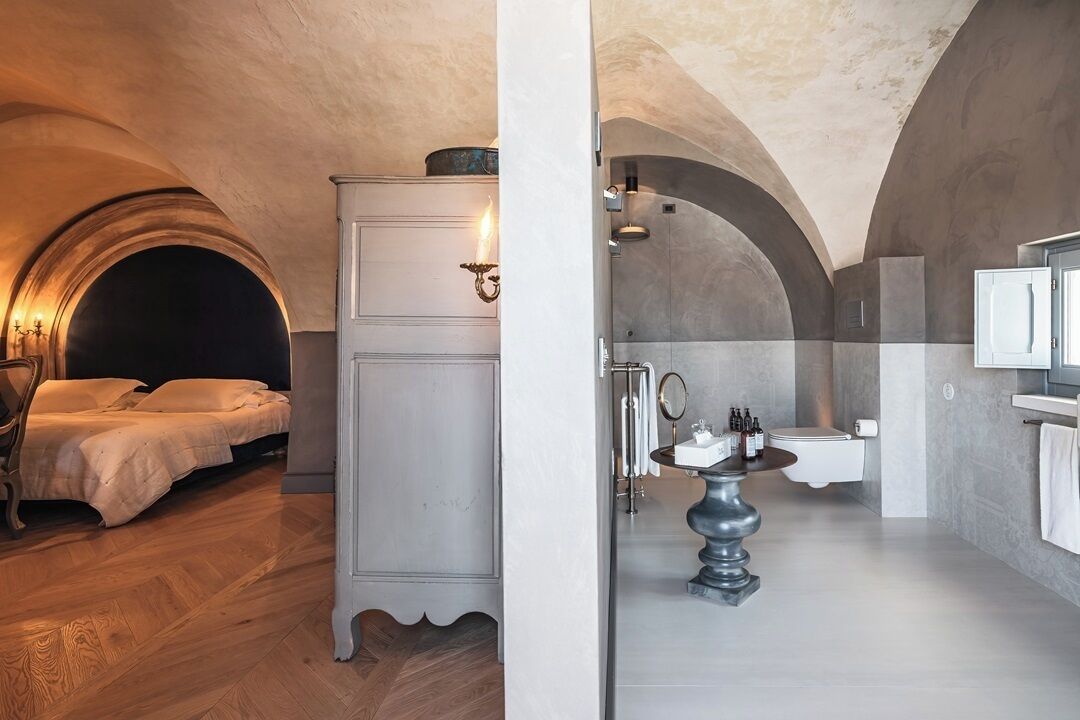 A bedroom with a bed and a wardrobe, and a bathroom with a sink and toilet.