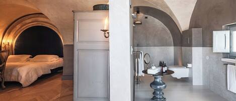 A bedroom with a bed and a wardrobe, and a bathroom with a sink and toilet.