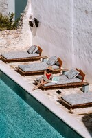 Una piscina al aire libre, sombrillas, tumbonas