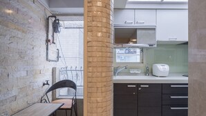 A kitchen with a brick wall, a window, a sink, and a toaster. - Comfy & Central 2B1b, Sleeps 5, 3min to Daan MRT (Taipei)