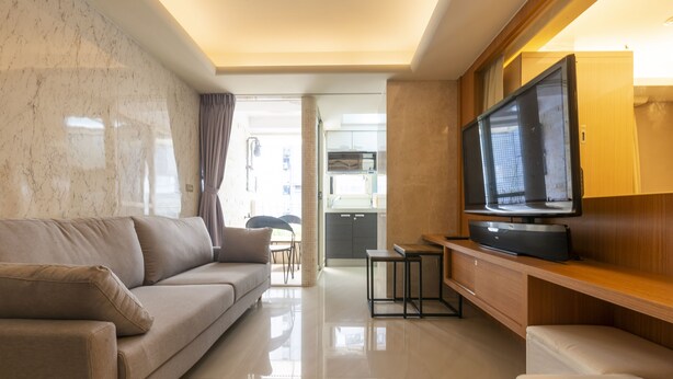 A modern living room with a sofa, a flat-screen TV, and a wooden entertainment unit. - Comfy & Central 2B1b, Sleeps 5, 3min to Daan MRT (Taipei)