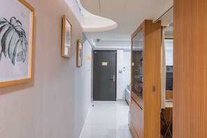 A hallway with framed artwork, a door, and a wooden cabinet. - Comfy & Central 2B1b, Sleeps 5, 3min to Daan MRT (Taipei)