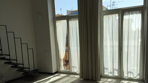 A room with a staircase, large windows with sheer curtains, and a view of the outside. - SweetHomeToledo Historical Center (Napoli)