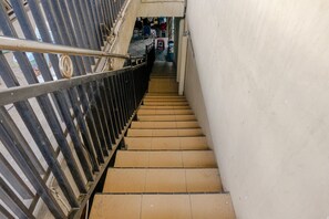 Una escalera con barandillas de metal y suelo de baldosas.