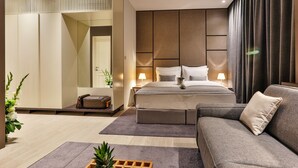 Un dormitorio moderno con una cama, un sofá, una mesita de noche y un espejo.
