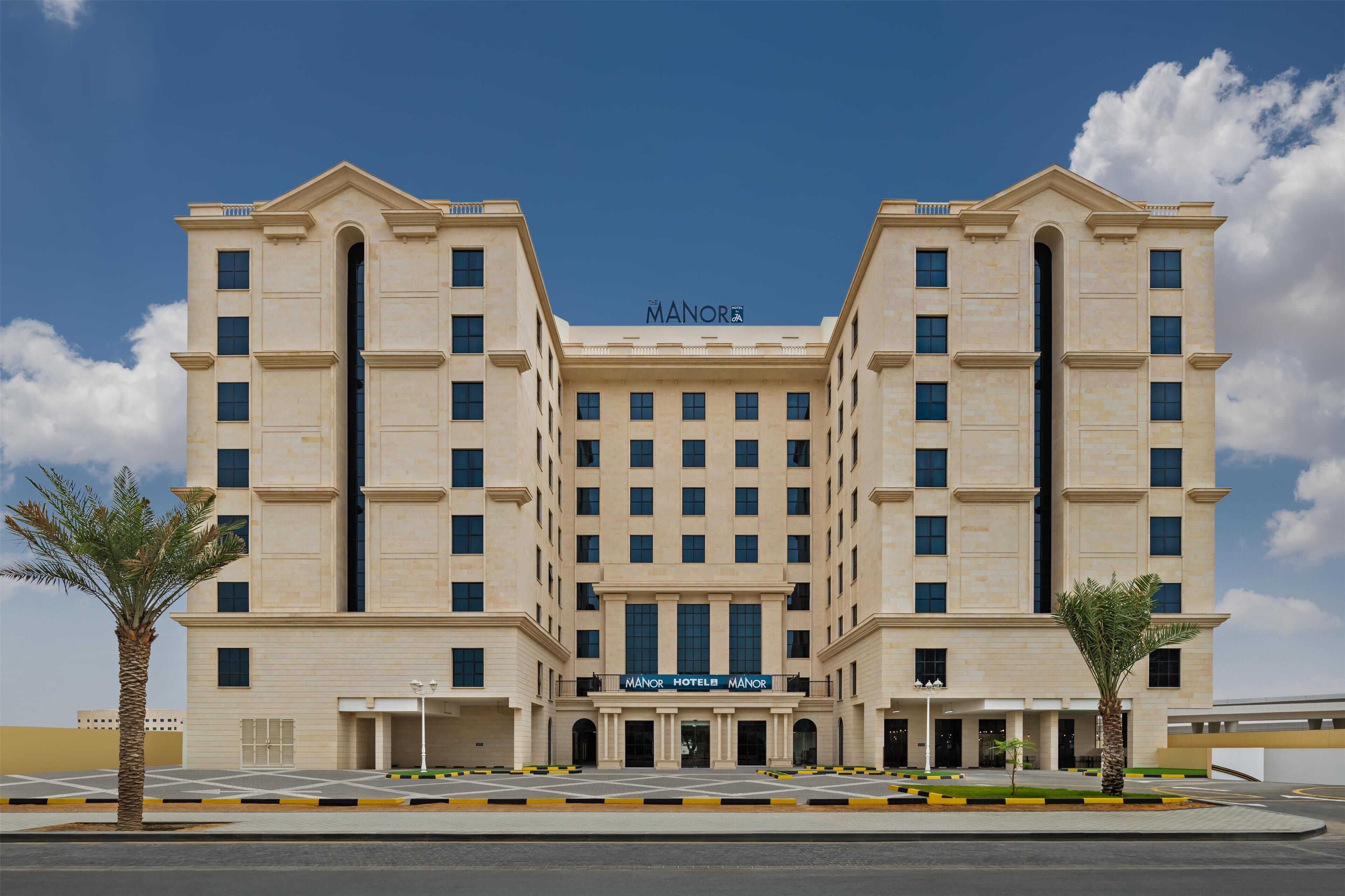 Un gran edificio hotelero simétrico con una entrada central y varios pisos.