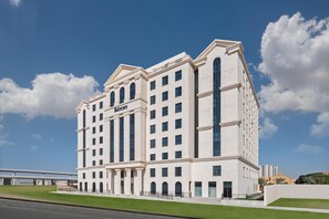 A large, multi-story hotel with a classic architectural style, featuring a prominent entrance and a name sign. - JA The Manor Hotel, Dubai (Dubai)