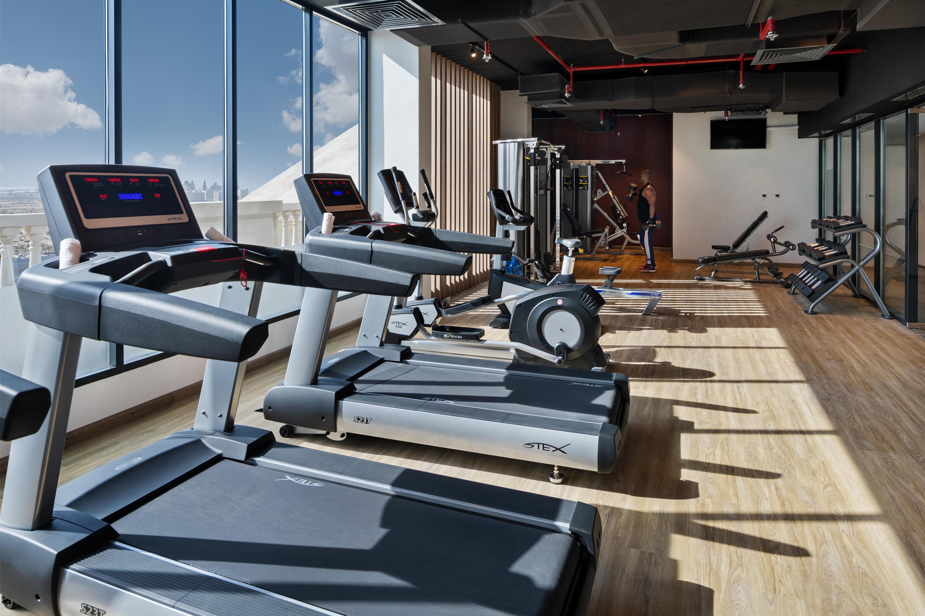 A gym with treadmills, elliptical machines, and weight equipment.