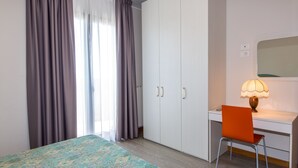 A bedroom with a bed, a desk, and a chair. - Residence California (Jesolo)