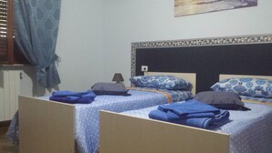 A bedroom with two single beds, each with a patterned bedspread and pillows. - B&B Della Ciociaria (Ceprano)