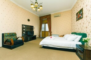 Une chambre d’hôtel avec un lit, un canapé, une télévision et un mur décoratif.