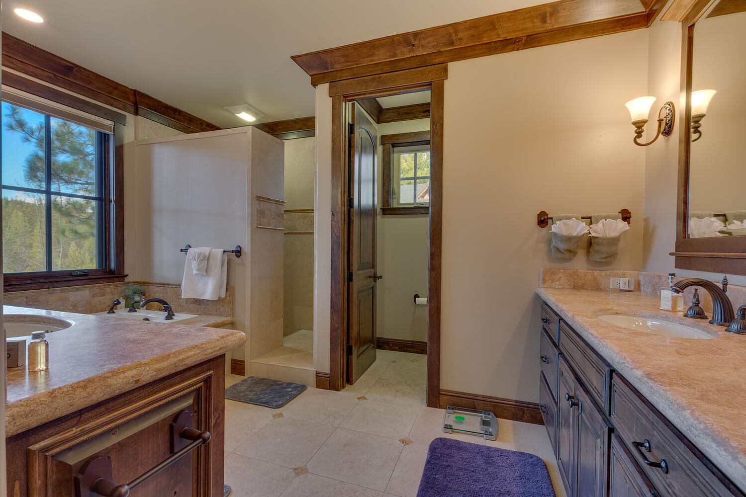 A modern bathroom with a large vanity, a walk-in shower, and a large mirror.