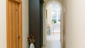 A hallway with a wooden door, a dark-colored cabinet, and a vase with flowers. - Kyiv Home near Arena Khreschatyk (Kyiv)