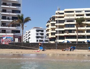 A beachfront with a hotel, beach chairs, umbrellas, and a sign for 'Excursions'. - Great location, close to the beach (Arrecife)