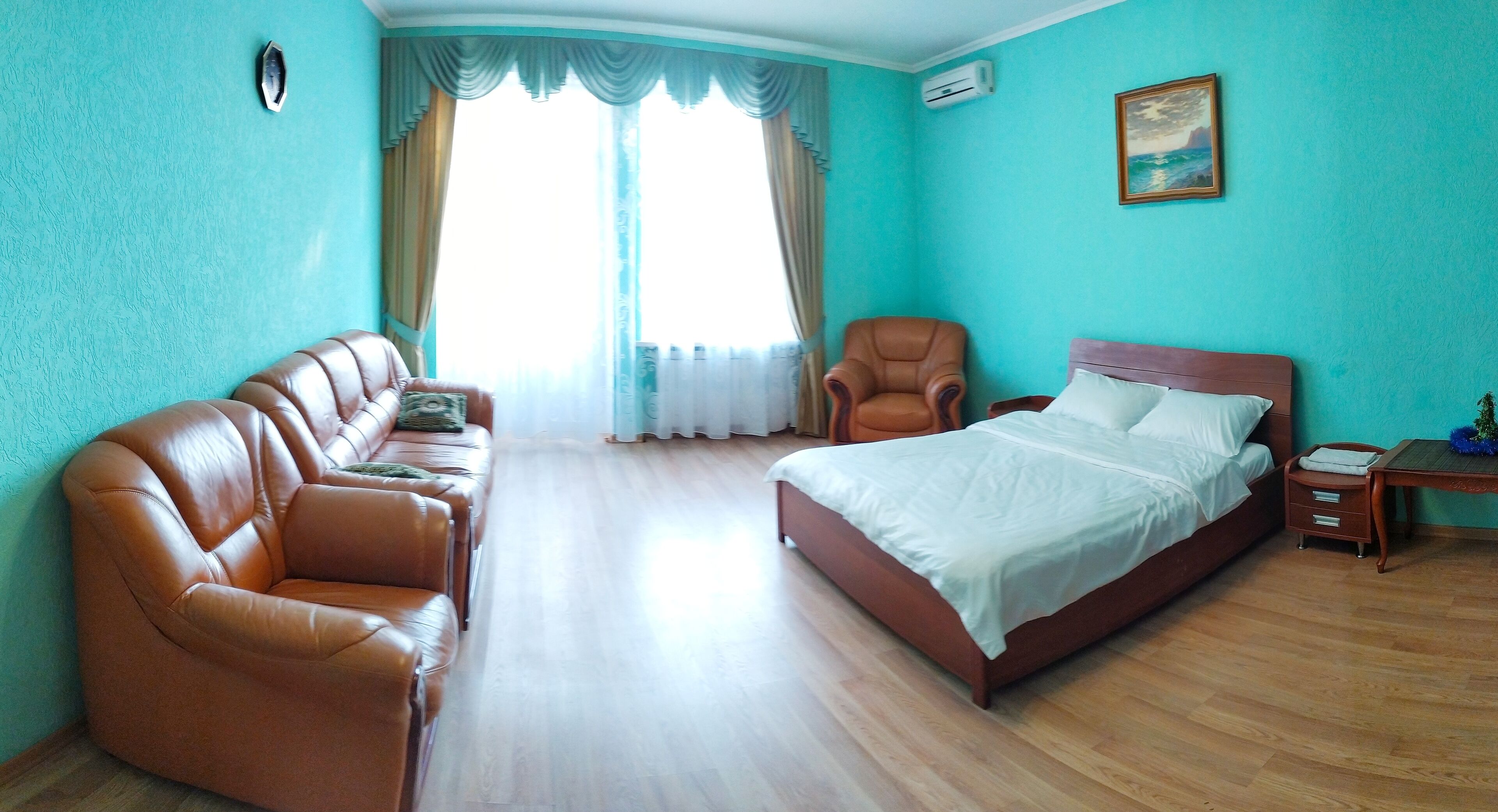 Une chambre à coucher avec un lit, un canapé, une chaise et une table de chevet.