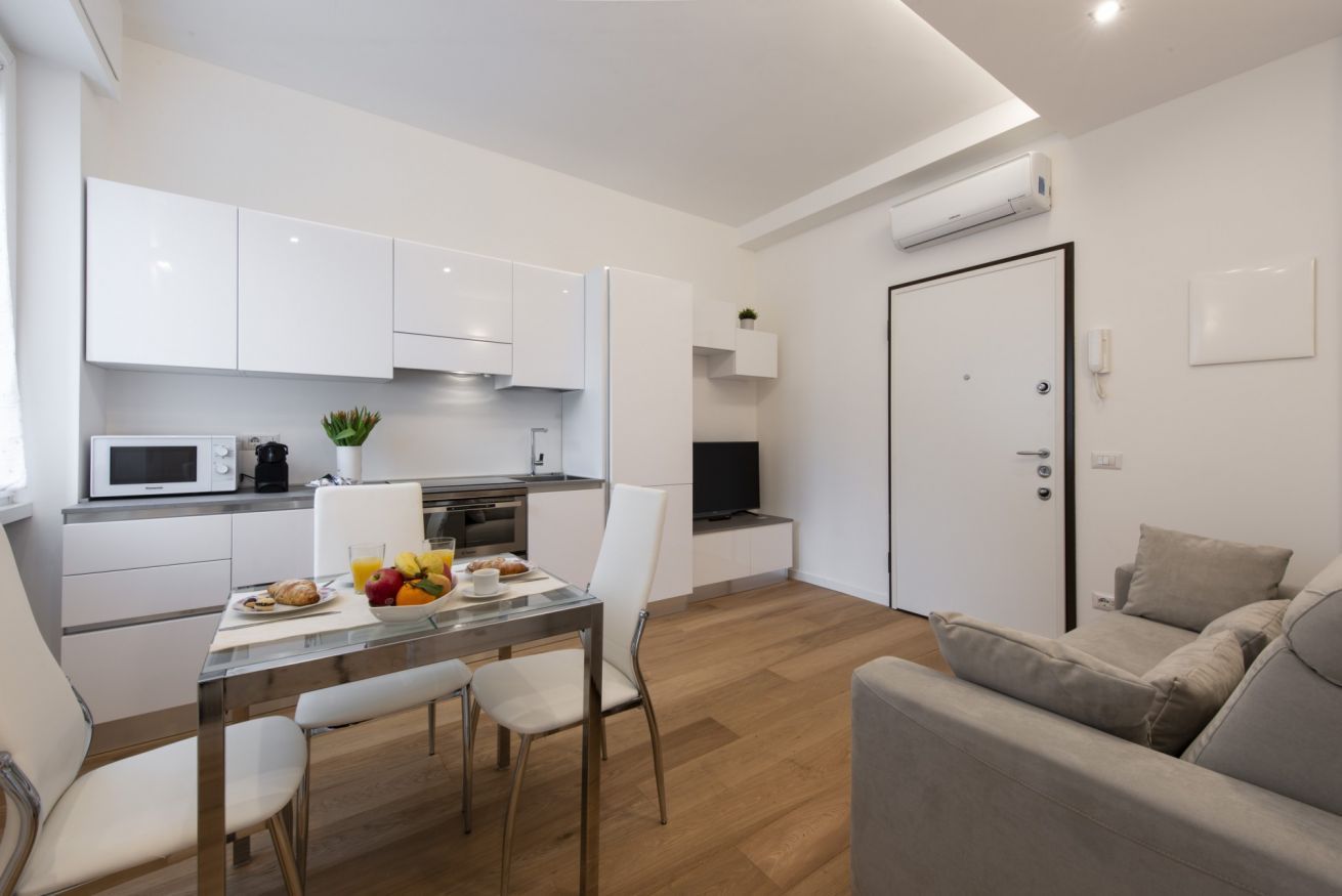 A modern apartment with a kitchen, dining area, and living room.