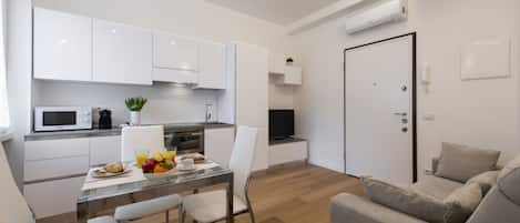 A modern apartment with a kitchen, dining area, and living room.