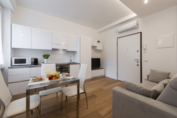 A modern apartment with a kitchen, dining area, and living room.