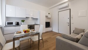 A modern apartment with a kitchen, dining area, and living room. - BnButler - Friuli, 24 (Milano)
