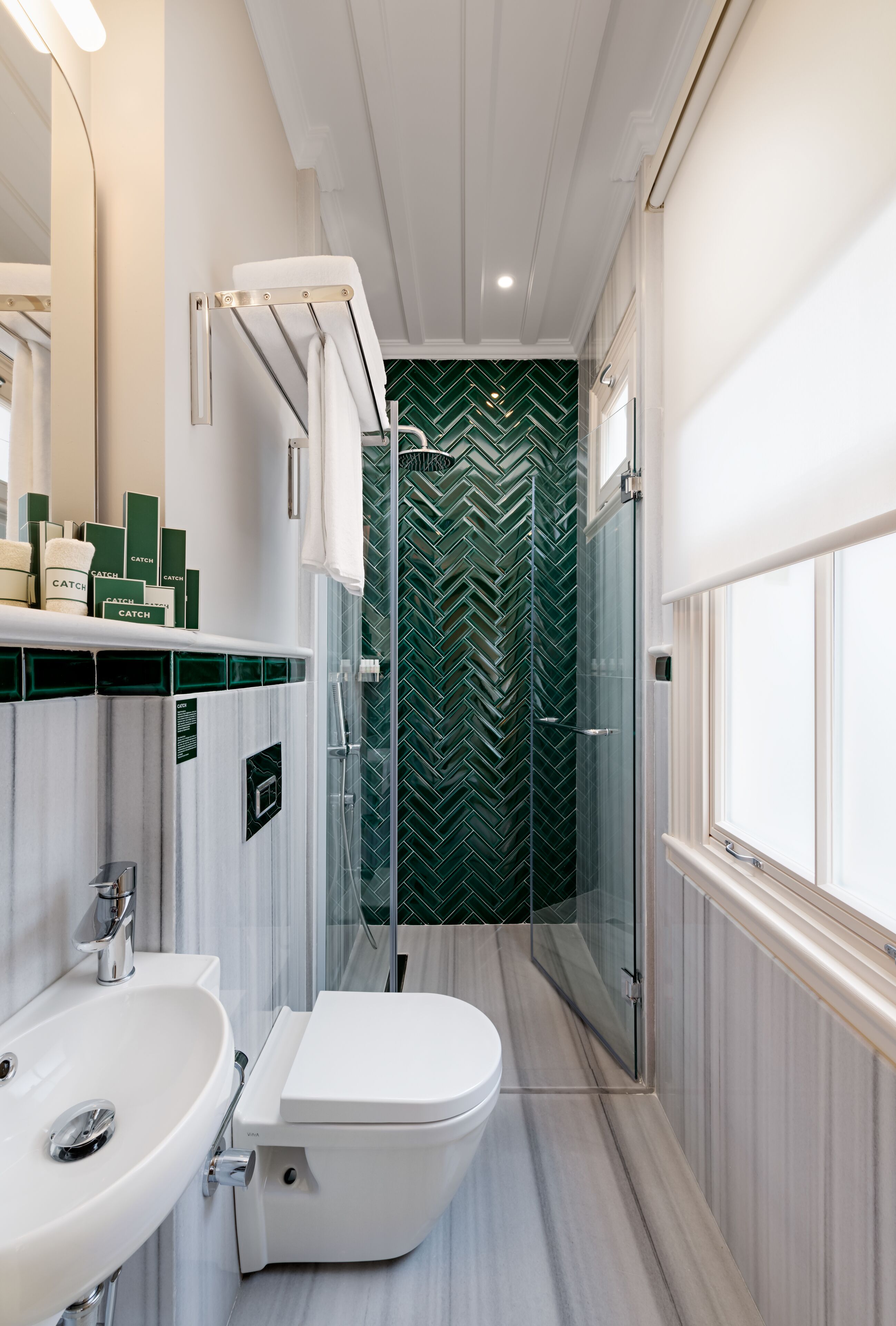A modern bathroom with a white sink, toilet, and shower area.
