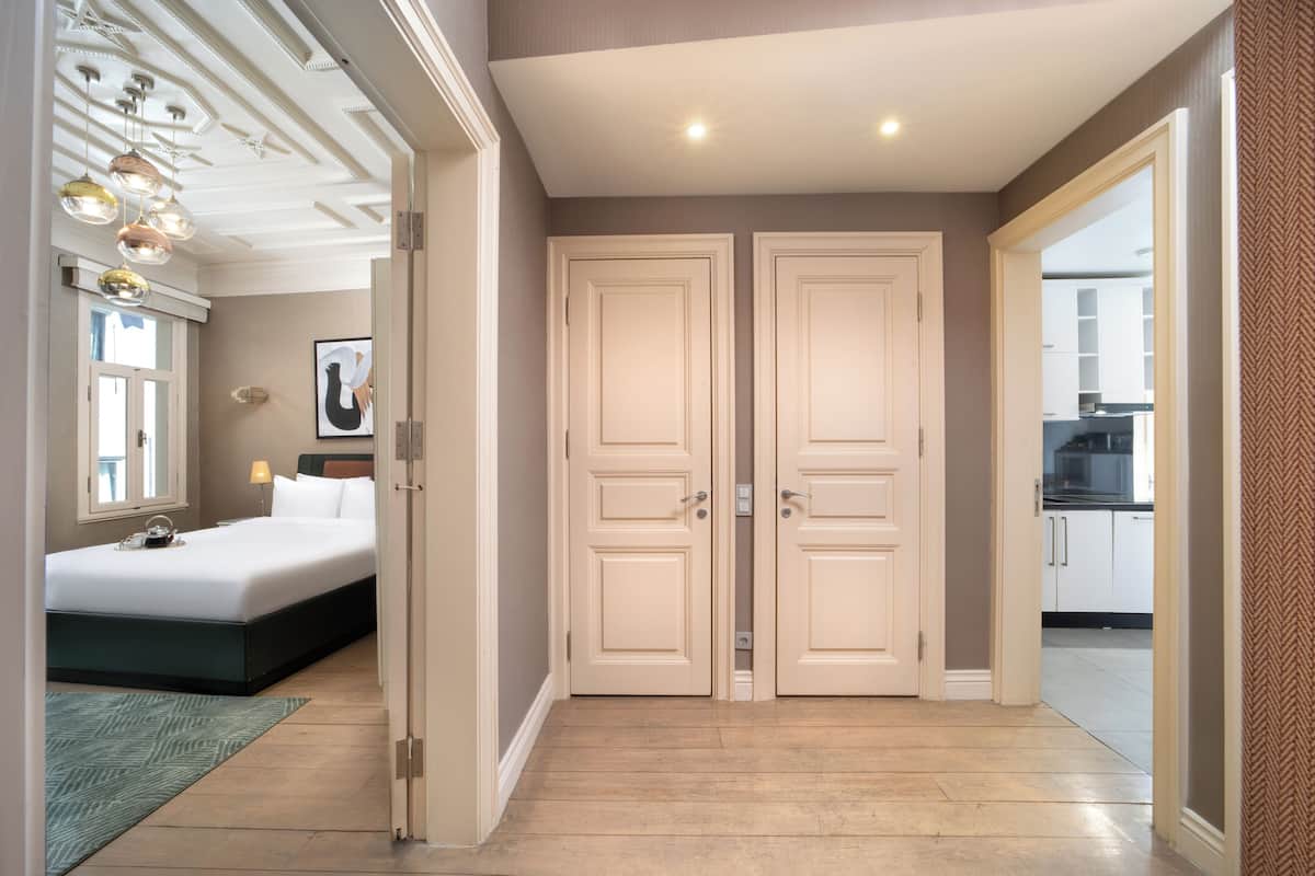 A bedroom with a bed, bedside table, lamp, and a framed picture on the wall.