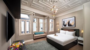 Ein Hotelzimmer mit einem großen Bett, einem Flachbildfernseher, einer Sitzecke und einem Fenster mit Aussicht.