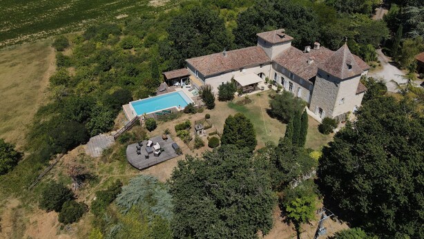 An aerial view of a large estate with a swimming pool, outdoor seating area, and a stone building with multiple towers. - Chambres d'Hotes Las Caneres (Castelnau-d'Arbieu)