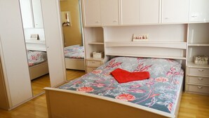 Une chambre à coucher avec un lit, une armoire et un miroir.