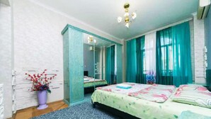 A bedroom with a bed, a mirror, a dresser, and a potted plant. - KyivHome at Khreschatyk (Kyiv)