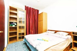 Ein Schlafzimmer mit einem Bett, einem Kleiderschrank und einer eingebauten Schrankwand.