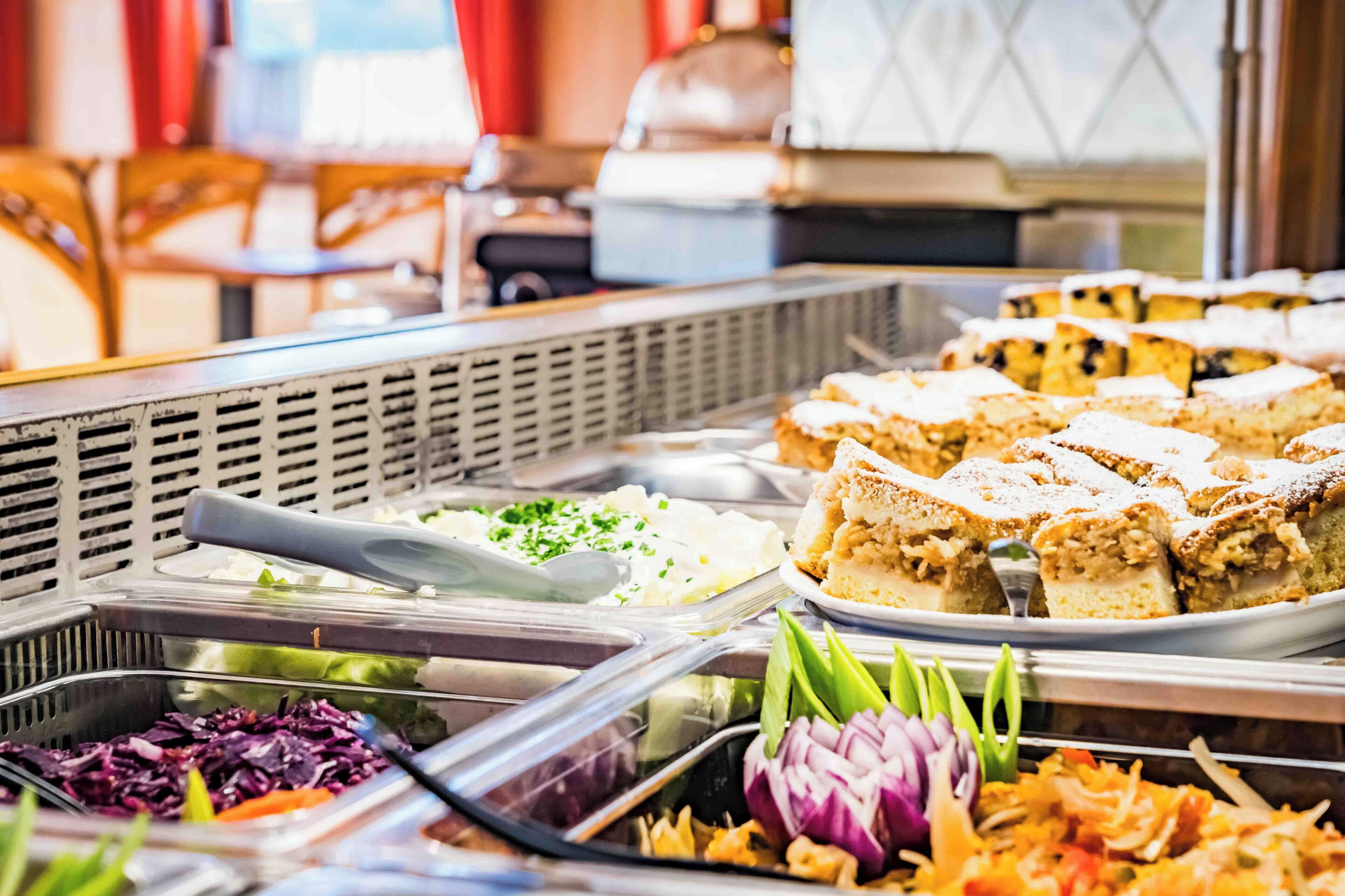 Buffet-pöydässä on tarjolla monenlaisia ruokia, kuten salaatteja, voileipiä ja erilaisia lisukkeita.