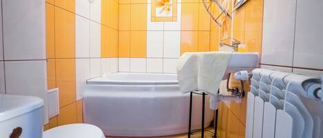 A bathroom with a toilet, bathtub, and a towel rack.