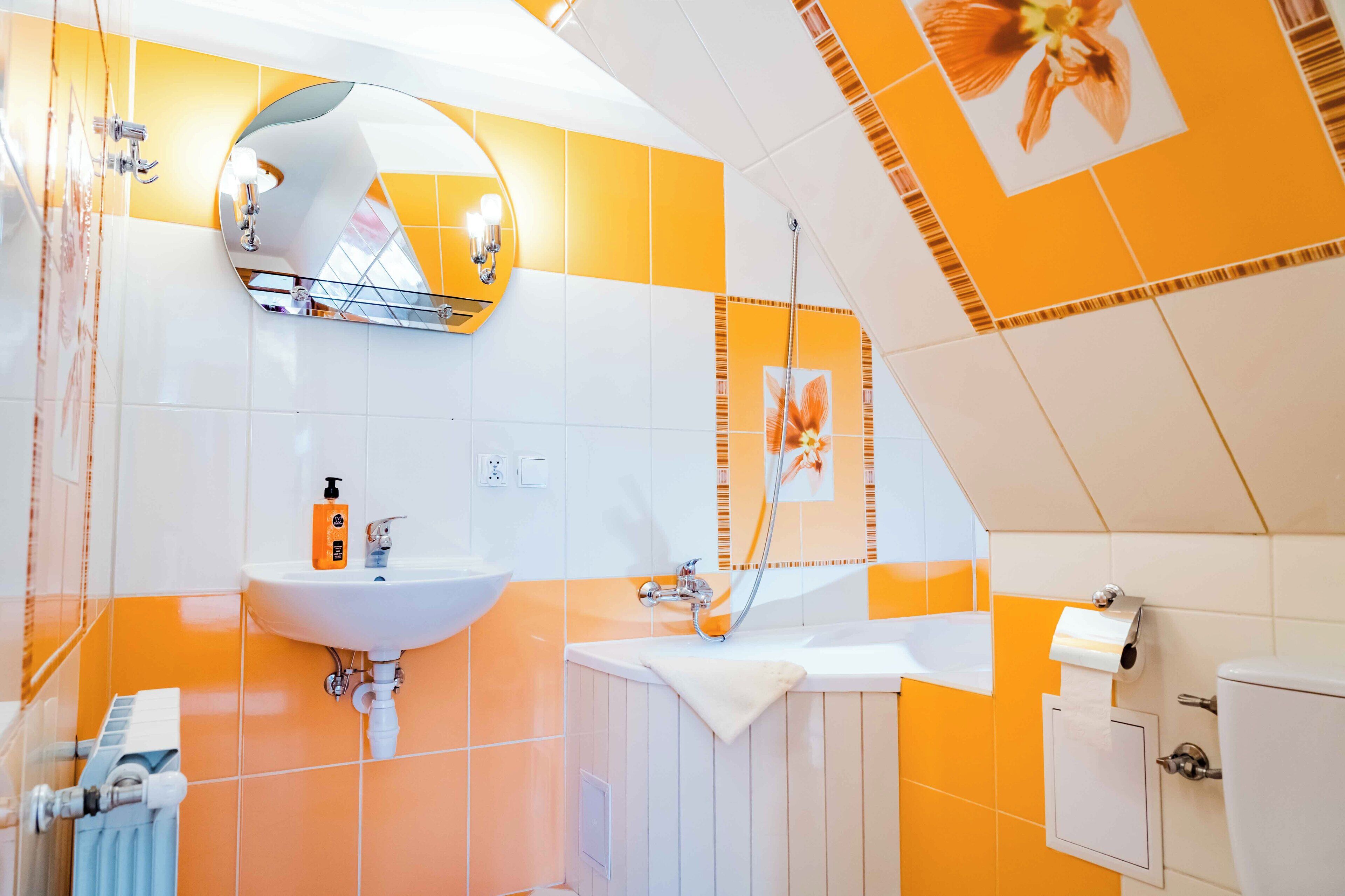 A bathroom with a white sink, mirror, and shower.