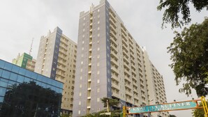 A high-rise residential building with multiple balconies and a sign indicating 'KAWASAN KULINER'. - OYO 2103 Lauv Room 2 Grand Centerpoint Tower B (Bekasi)