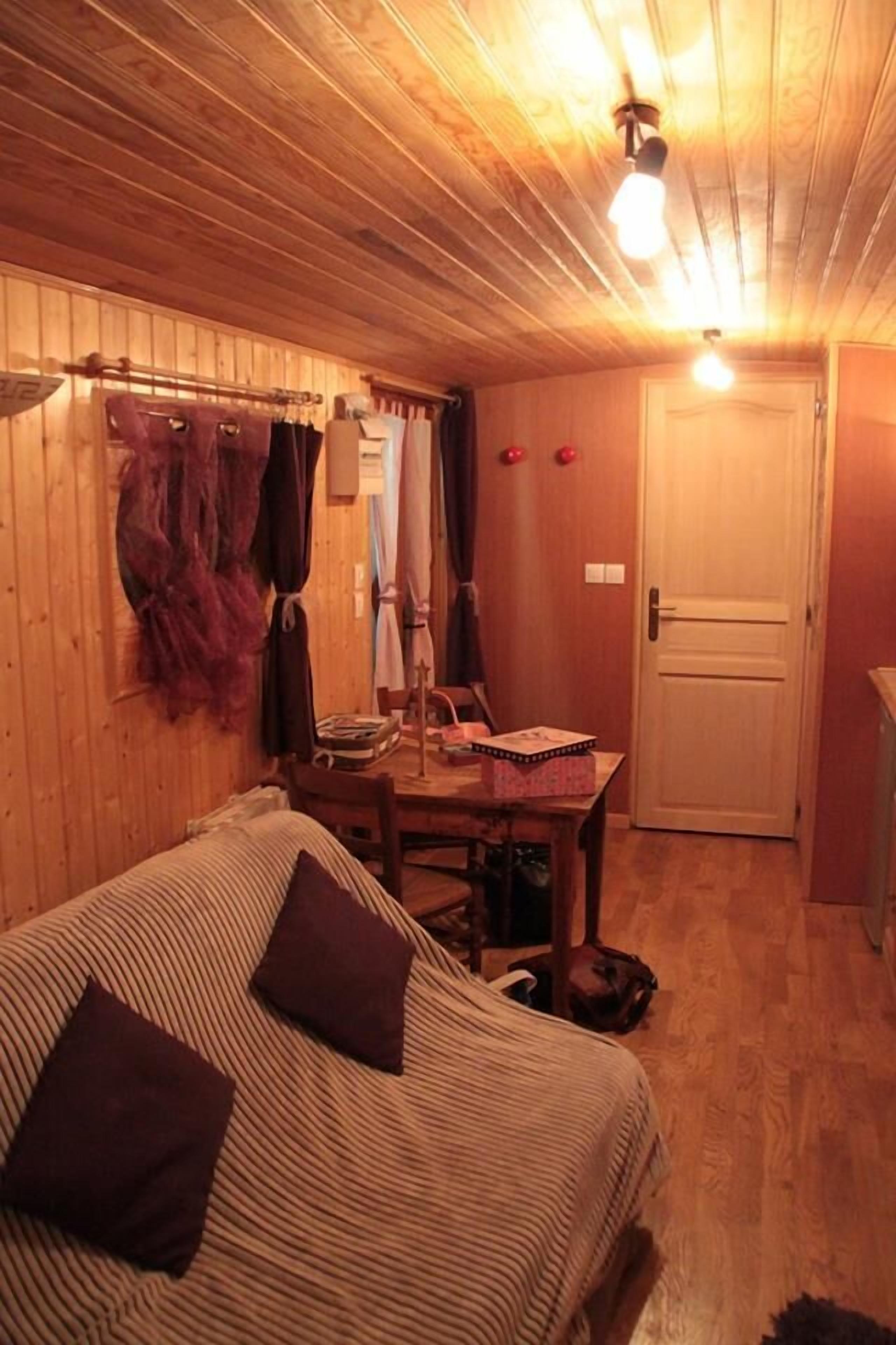 Una habitación acogedora con cama, una mesa y una puerta.
