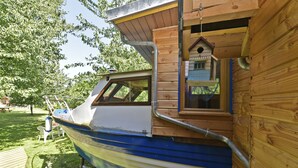 A boat house with a window and a wooden exterior. - Roulotte la Verdine (Dury)