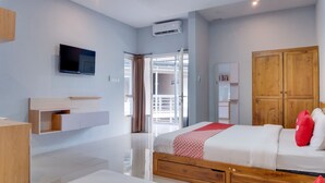 Une chambre d’hôtel moderne dotée d’un grand lit, d’une télévision, d’une armoire et d’un balcon.