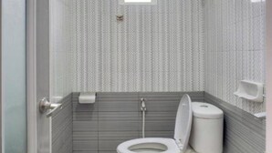 Une petite salle de bain comprenant des toilettes, une fenêtre et une douche.